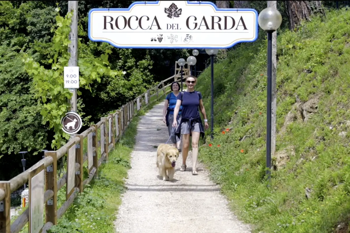 persone con cane passeggiano a Rocca del Garda La Rocca Camping Village